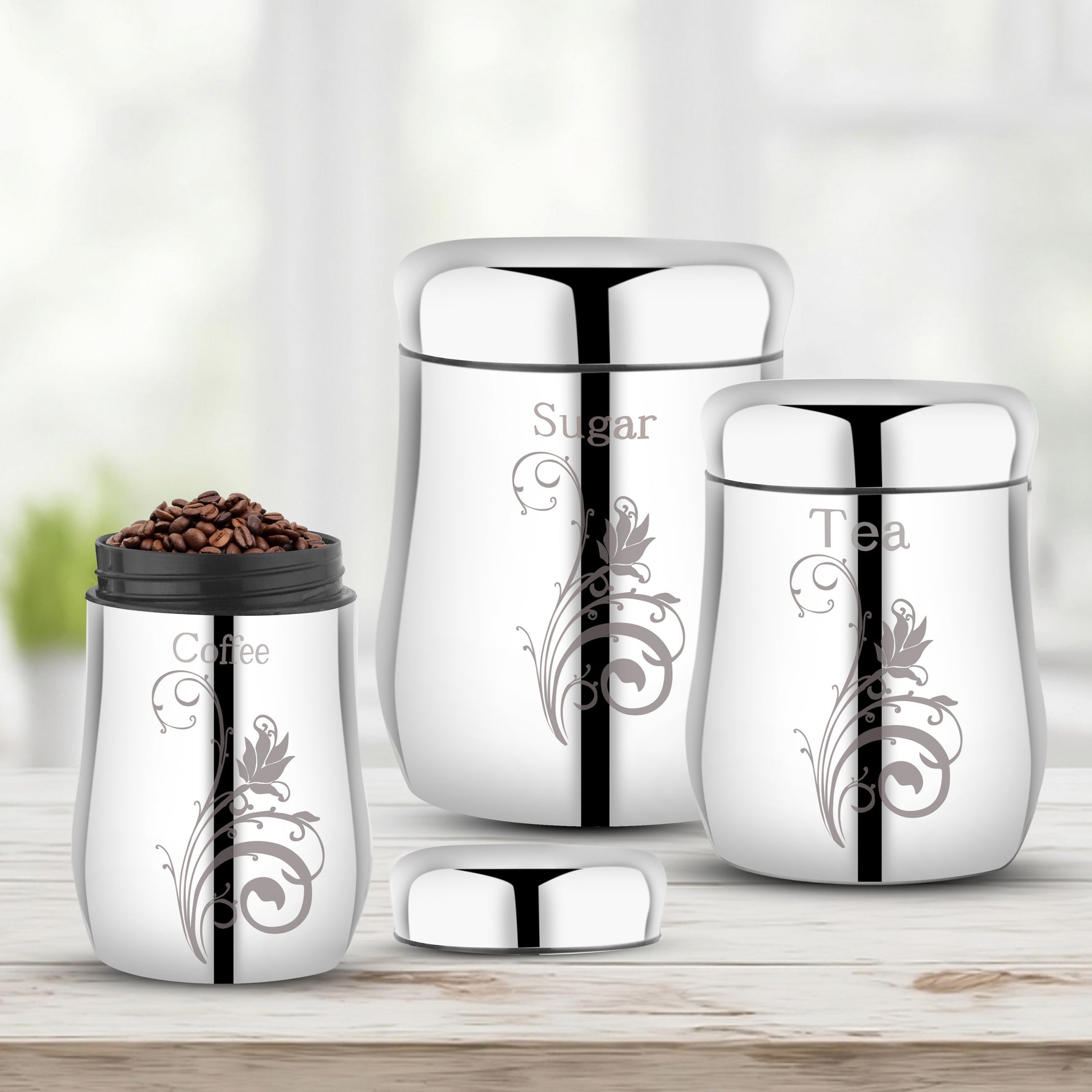 A 3-piece set of kitchen canisters with one lid open and coffee beans inside, arranged on a light wood surface.