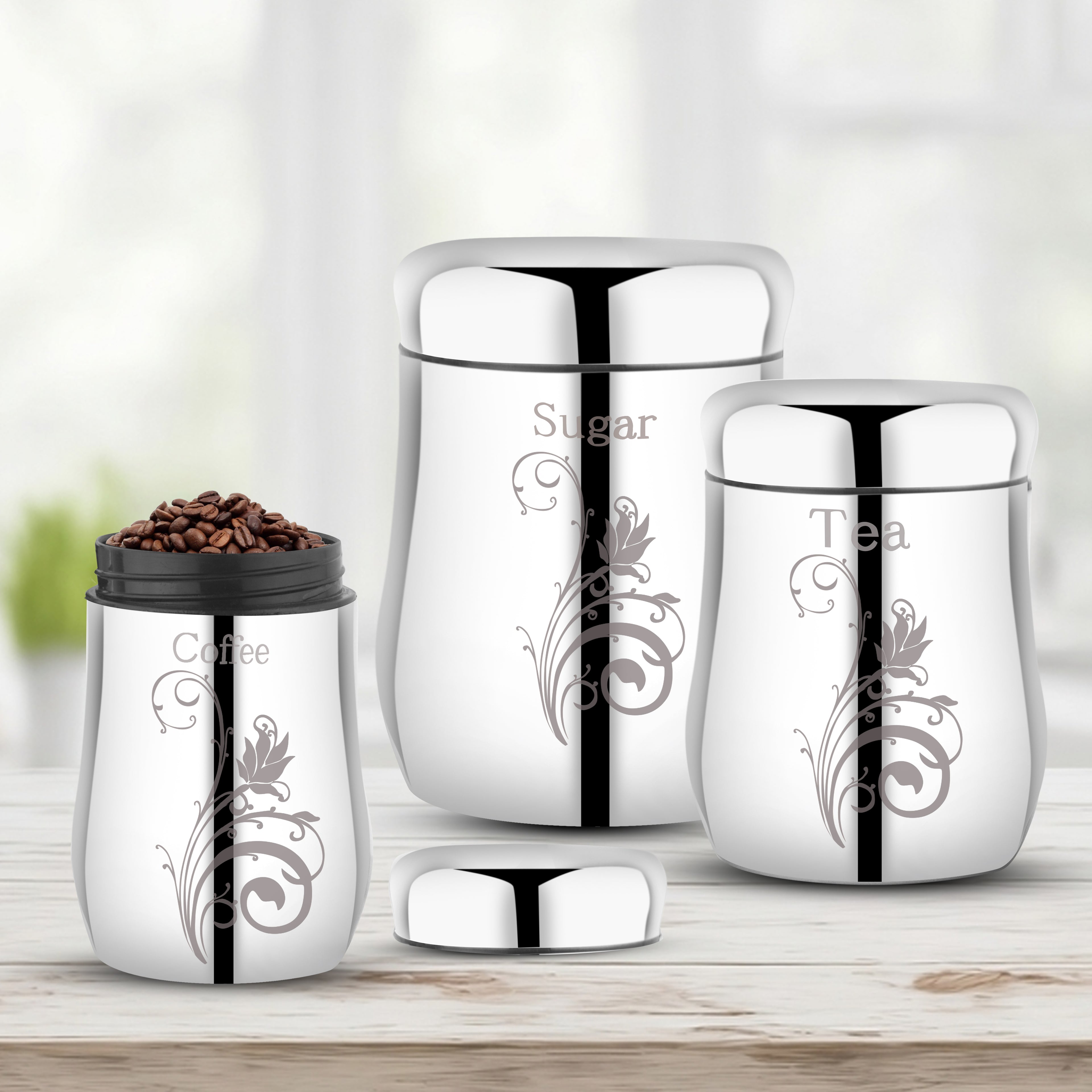 A 3-piece set of kitchen canisters with one lid open and coffee beans inside, arranged on a light wood surface.